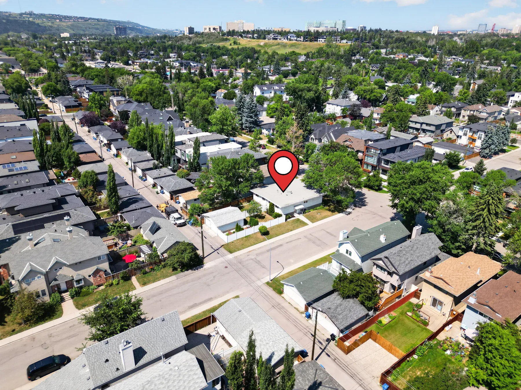 Aerial view of 2301 4 Ave NW and the surrounding West Hillhurst streetscape, inner-city Calgary.
